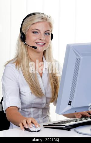 Jeune femme avec casque et ordinateur à la hotline Banque D'Images
