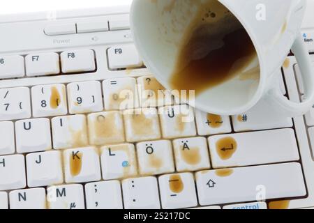 Tasse de café renversé sur un clavier d'ordinateur. Dommages pour assurance, tasse de café renversé sur un clavier d'ordinateur. Assurance dommages. Autriche Banque D'Images