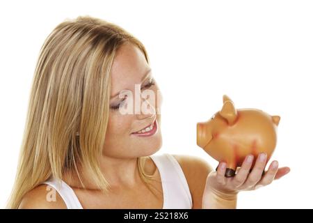 Une jeune femme économise de l'argent et des pièces pour l'avenir. Provision pour pensions et épargne. Autriche Banque D'Images