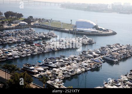 San Diego, Californie, États-Unis. 20 décembre 2024. Une perspective aérienne du Marriott Marquis Hotel Marina à San Diego, présentant un arrangement animé de bateaux et yachts amarrés dans des glissements à court et à long terme. Photographiée depuis un étage élevé de l'hôtel, l'image capture l'atmosphère sereine du front de mer avec la disposition organisée de la marina, les palmiers encadrant la scène et le bleu vif de l'eau. En arrière-plan, un parc et un pavillon blanc ajoutent du contraste, complétant l'environnement marin vivant mais tranquille. (Crédit image : © Ian L. Sitren/ZUMA Press Wire) USAGE ÉDITORIAL SEULEMENT! Non Banque D'Images