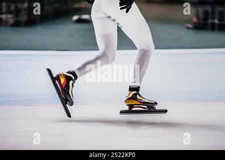 patineuse de vitesse féminine jambes en costume de peau blanche et patins Banque D'Images