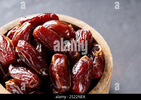 Dattes séchées biologiques dans un bol en bois rustique, Ramadan et cuisine du moyen-Orient Banque D'Images