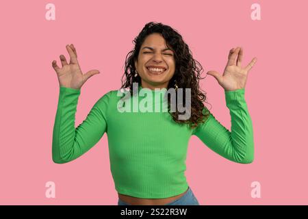 Jeune femme ludique faisant un geste drôle de griffes avec ses mains, souriant, exprimant la joie et l'amusement Banque D'Images