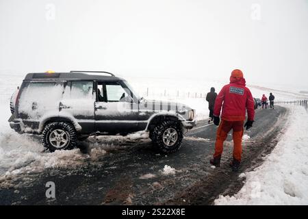 Membre d'une équipe Mountain Rescue après avoir aidé à dégager des voitures d'une dérive de neige près de Ribblehead, dans le North Yorkshire. De grandes parties du Royaume-Uni sont confrontées à de fortes chutes de neige et à des pluies verglaçantes, ce qui est susceptible de causer des perturbations, après l'entrée en vigueur de deux avertissements météorologiques jaunes. Des véhicules bloqués sur les routes, des voyages ferroviaires et aériens retardés ou annulés, et des coupures de courant sont tous probables alors que le pays est aux prises avec une période hivernale d'une semaine, a déclaré le met Office. Date de la photo : lundi 6 janvier 2025. Banque D'Images
