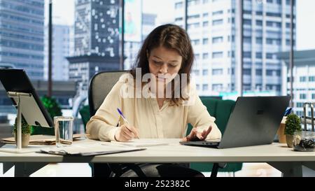 Leader féminin avec un pouvoir exécutif signant des contrats de travail et approuvant les demandes des employés, tâches administratives quotidiennes pour la productivité. Autorisation de demande de congé ou contrat de licence. Caméra A. Banque D'Images