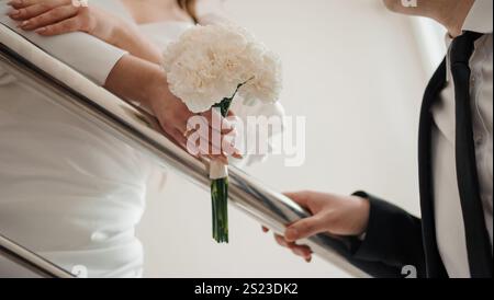 Moment de mariage intime entre une mariée et un marié avec un bouquet floral. Banque D'Images