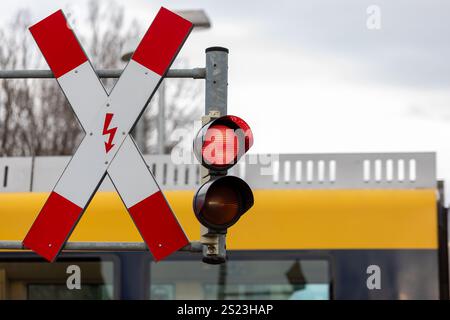 Traversée ferroviaire électrifiée allemande avec feu rouge et panneau de signalisation Banque D'Images