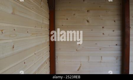 coin intérieur de deux murs en bois faits de planches horizontales rabotées et de poutres verticales peintes en brun, fragment d'une dépendance du village ou d'une grange Banque D'Images
