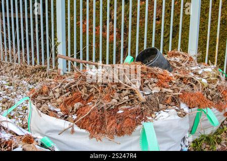 Un tas de déchets de cour rempli de feuilles et de branches est prêt pour la collecte dans un quartier de banlieue à la fin de l'automne. Banque D'Images