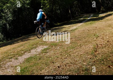 Un cycliste circule le long d'un chemin forestier Banque D'Images