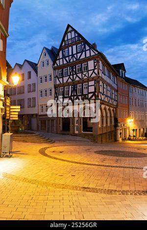 Rue illuminée du centre-ville avec maisons à colombages à Wetzlar sur le Lahn avec boutiques, lampes et reflets Banque D'Images
