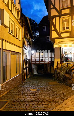 Rue illuminée du centre-ville avec maisons à colombages à Wetzlar sur le Lahn avec boutiques, lampes et reflets Banque D'Images