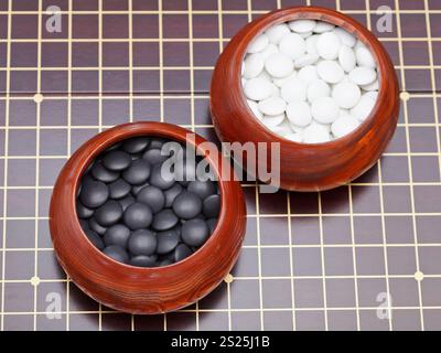 Ensemble de jeu de go en noir et blanc des pierres dans des bols en bois Banque D'Images