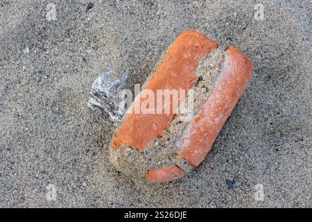 Beauté d'une vieille brique, lavée de la mer pendant la marée haute. Bords arrondis de la puissance de la mer. Plage de la mer Tyrrhénienne, Sicile, Italie. Banque D'Images