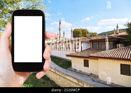 Concept de voyage - photo touristique douves et murs du palais de Khan (Hansaray) à Bakhchisaray, Crimée sur smartphone avec écran découpé avec pl vierge Banque D'Images