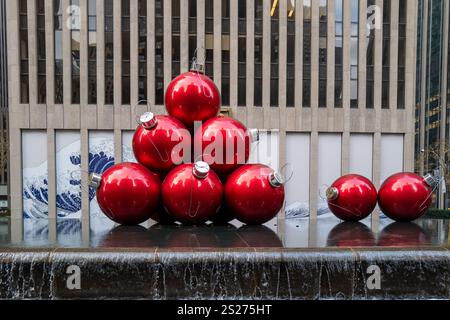 Une fontaine à New York est décorée de boules géantes de sapin de Noël rouges Banque D'Images