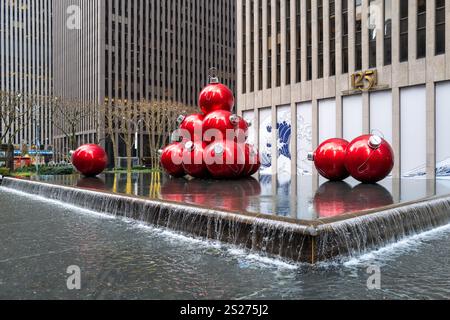 Une fontaine à New York est décorée de boules géantes de sapin de Noël rouges Banque D'Images