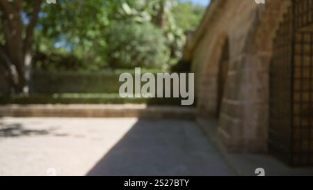 Scène extérieure floue à majorque, espagne, avec une architecture défocalisée, de la verdure, des murs de pierre, et le temps ensoleillé. Banque D'Images