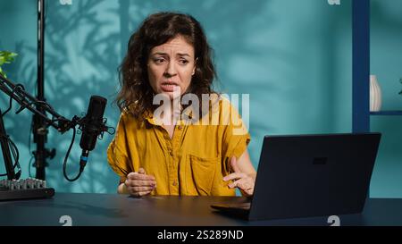 Influenceur se sentant en colère, partageant une histoire concernant les médias sociaux vidéo, parlant aux fans. Le créateur de contenu frustré parle avec les téléspectateurs, ayant une dépression mentale devant les abonnés, caméra A. Banque D'Images