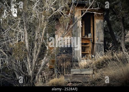Une terrasse en bois délabrée cachée dans les bois, maintenant utilisée pour le stockage tout en vivant hors de la grille nord du Nouveau-Mexique Banque D'Images