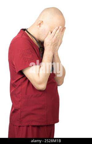 Un professionnel de santé masculin chauve avec une barbe porte des gommages rouges et a un stéthoscope autour de son cou. Banque D'Images