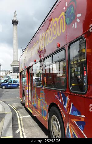 Bus à impériale rouge dans la rue avec un grand monument en arrière-plan, colonne Nelson, mémorial à l'amiral Horatio Nelson, Londres, Londres, Londo Banque D'Images