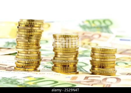 Pile de pièces, courbe descendante, photo symbolique pour la baisse des taux d'intérêt et la baisse des coûts Autriche Banque D'Images