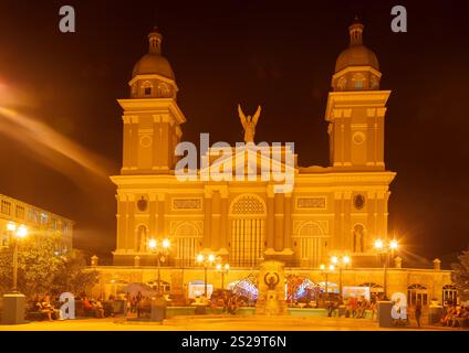 La cathédrale basilique de notre-Dame de l'Assomption façade avec ses tours jumelles et statue d'ange dans le Parque Cespedes la nuit, au centre-ville de Santiago de Cu Banque D'Images