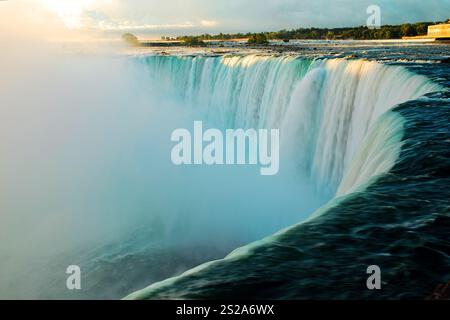 La brume des chutes canadiennes ou Horseshoe Falls dans les chutes du Niagara est mise en évidence dès la première lumière du jour sur l'eau Banque D'Images