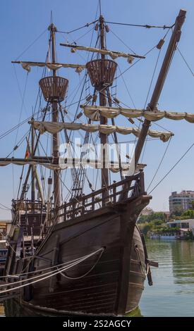 Séville, Espagne - 27 août 2024 : réplique de Nao Victoria, premier navire de circumnavigation, ancré sur les rives du Guadalquivir. Arc Banque D'Images