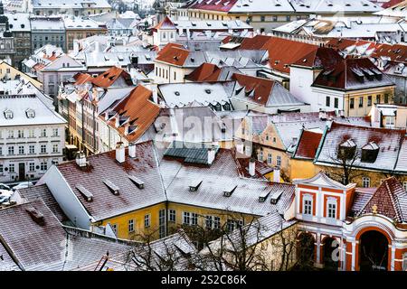 Toits enneigés de Malá Strana à Prague avec architecture historique et toits en tuiles rouges Banque D'Images