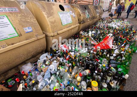 Munich, Allemagne. 07 janvier 2025. Des milliers de bouteilles et de bocaux en verre se dressent sur le trottoir devant des conteneurs de collecte surchargés au Postwiese dans le district de Haidhausen. Crédit : Peter Kneffel/dpa/Alamy Live News Banque D'Images