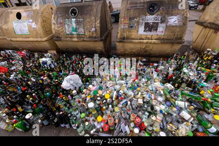 Munich, Allemagne. 07 janvier 2025. Des milliers de bouteilles et de bocaux en verre se dressent sur le trottoir devant des conteneurs de collecte surchargés au Postwiese dans le district de Haidhausen. Crédit : Peter Kneffel/dpa/Alamy Live News Banque D'Images