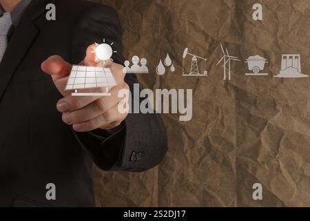 Cellule solaire point main icône avec le recyclage du papier froissé comme concept d'arrière-plan Banque D'Images