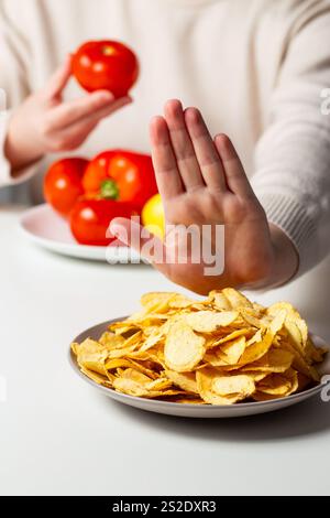 Plan vertical d'une femme disant « NON » aux jetons. Signe à main pour refuser la malbouffe. Choisir une alimentation saine. Essayer de manger des légumes. Une alimentation saine pour Weig Banque D'Images