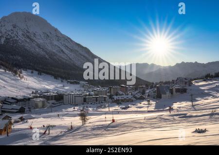 La vue imprenable sur un paysage hivernal pittoresque comprend des montagnes majestueuses et enneigées, un village pittoresque et serein Montgenevre niché dans le Banque D'Images