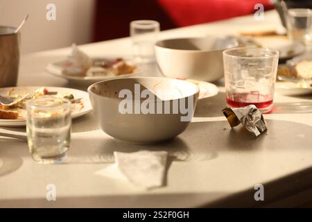 Videz les assiettes sales avec les cuillères et les fourchettes sur la table après le repas. Concept de fin de réception. Vaisselle non lavée prête à être nettoyée Banque D'Images