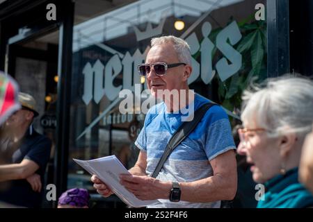 Un guide touristique de Meetup parlant au groupe dans une rue animée de Camden. Banque D'Images
