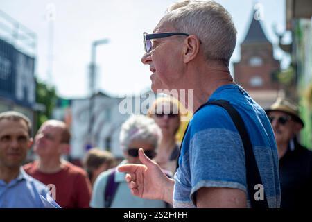 Un guide touristique de Meetup parlant au groupe dans une rue animée de Camden. Banque D'Images