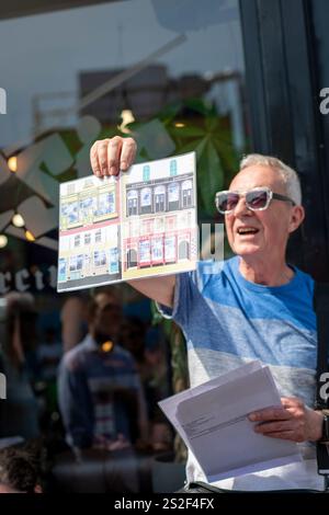 Un guide touristique de Meetup parlant au groupe dans une rue animée de Camden. Banque D'Images