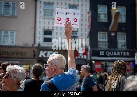 Un guide touristique de Meetup parlant au groupe dans une rue animée de Camden tenant une pancarte Banque D'Images