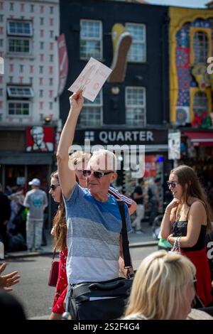 Un guide touristique de Meetup parlant au groupe dans une rue animée de Camden. Banque D'Images