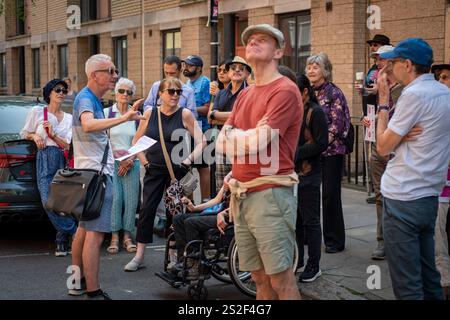 Un guide touristique de Meetup parlant au groupe dans une rue animée de Camden. Banque D'Images