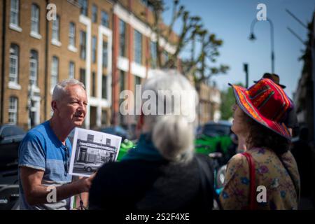Un guide touristique de Meetup parlant au groupe dans une rue animée de Camden. Banque D'Images