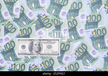 le billet de 100 dollars se trouve sur un ensemble de coupures monétaires vertes de 100 euros. Beaucoup d'argent forme un tas infini Banque D'Images