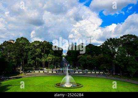 Une grande fontaine est au milieu d'un champ herbeux. La fontaine est entourée d'arbres et est située dans un parc Banque D'Images
