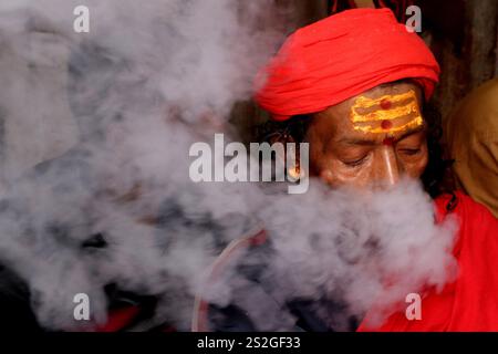 Kolkata, Inde. 07 janvier 2025. Un sadhu indien (homme Saint hindou) fume du cannabis dans un camp de transit de la foire de Gangasagar à Kolkata, en Inde, le 7 janvier 2025. Le Gangasagar Mela est un festival hindou annuel qui se tient à Gangasagar, au Bengale occidental, où le fleuve Gange rencontre la baie du Bengale. La foire a lieu à l'ashram de Kapilmuni sur Gangasagar chaque année sur Makar Sankranti. Photos de Debajyoti Chakraborty. (Photo : Debajyoti Chakraborty/News images) à Kolkata, Inde le 1/7/2025. (Photo de Debajyoti Chakraborty/News images/Sipa USA) crédit : Sipa USA/Alamy Live News Banque D'Images