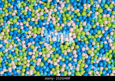 Photo d'arrière-plan d'une variété de vitrage de couleur en poudre sous forme de petites boules. Un nombre énorme de sucré, perles colorées de très petite taille pour décembre Banque D'Images