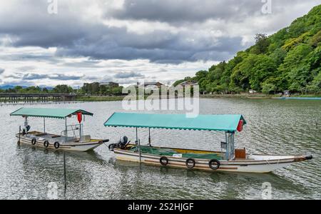 Paysage pittoresque d'Arashiyama avec des bateaux japonais au quai sur la rivière Katsura, à Kyoto. Banque D'Images