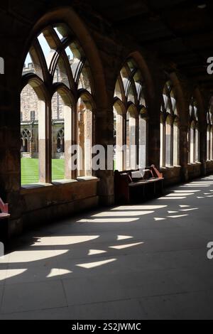 Le jeu de lumière et d'ombres projeté par les fenêtres cintrées dans le cloître intérieur de la cathédrale de Durham. Angleterre, Royaume-Uni. Banque D'Images